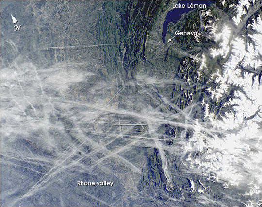 This digital photograph taken through the windows of the International Space Station on May 15, 2002, shows condensation trails over the Rhône Valley in the region west of Lyon. Condensation trails—or contrails—are straight lines of ice crystals that form in the wake of jet liners where air temperatures at altitude are lower than about ?40°C.